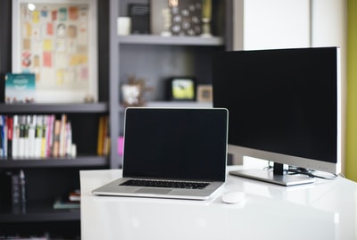 桌上银色显示器旁的MacBook Pro